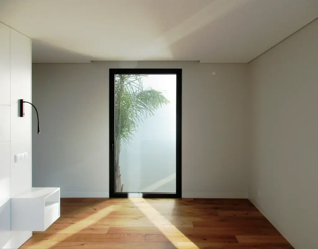 Bedrooms with windows onto patio with palm trees