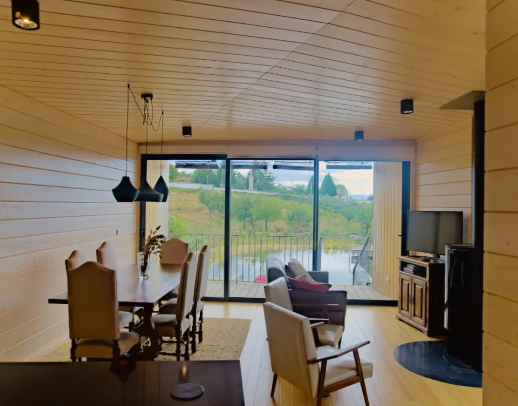 Wooden lounge and dining room overlooking the organic swimming pool